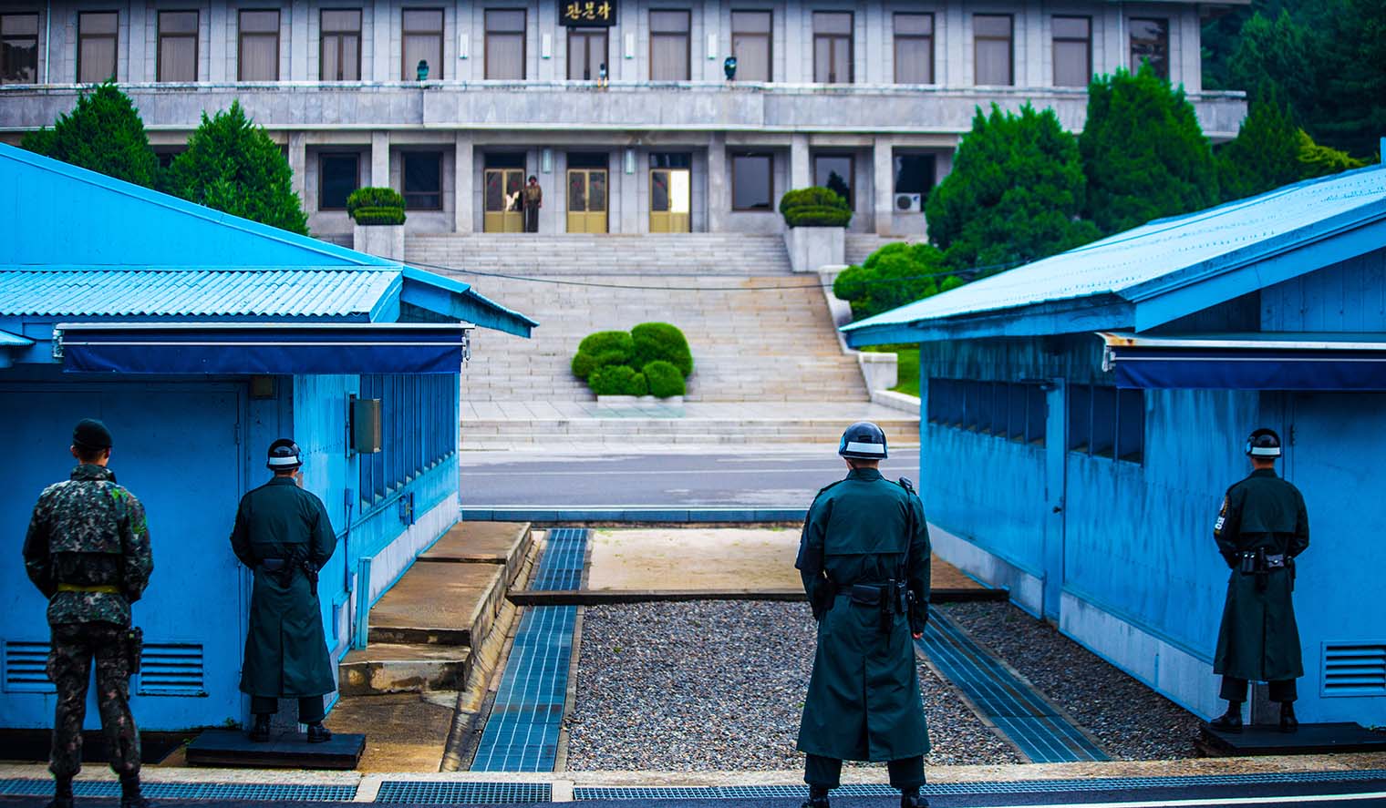 Soldaten stehen vor 2 blauen Militärhäusern in der Demilitarisierten Zone in Südkorea