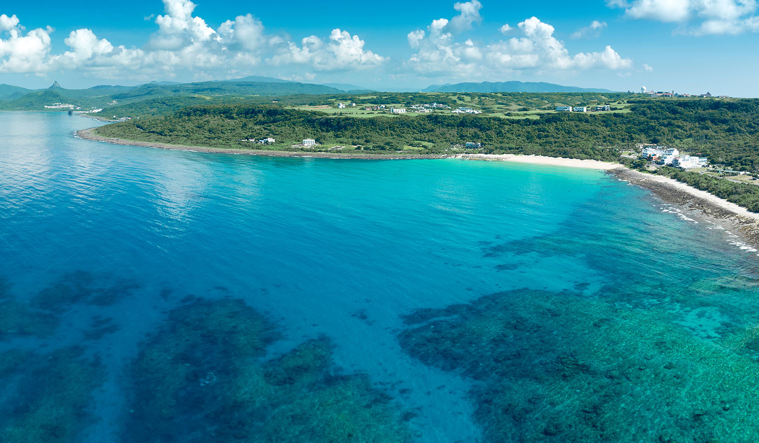 Taiwan Reisen zum Kenting Nationalpark mit atemberaubender Küstenlandschaft mit kristallklarem blauem Wasser und grünen Hügeln, einem Paradies für Naturliebhaber und Wassersportler.