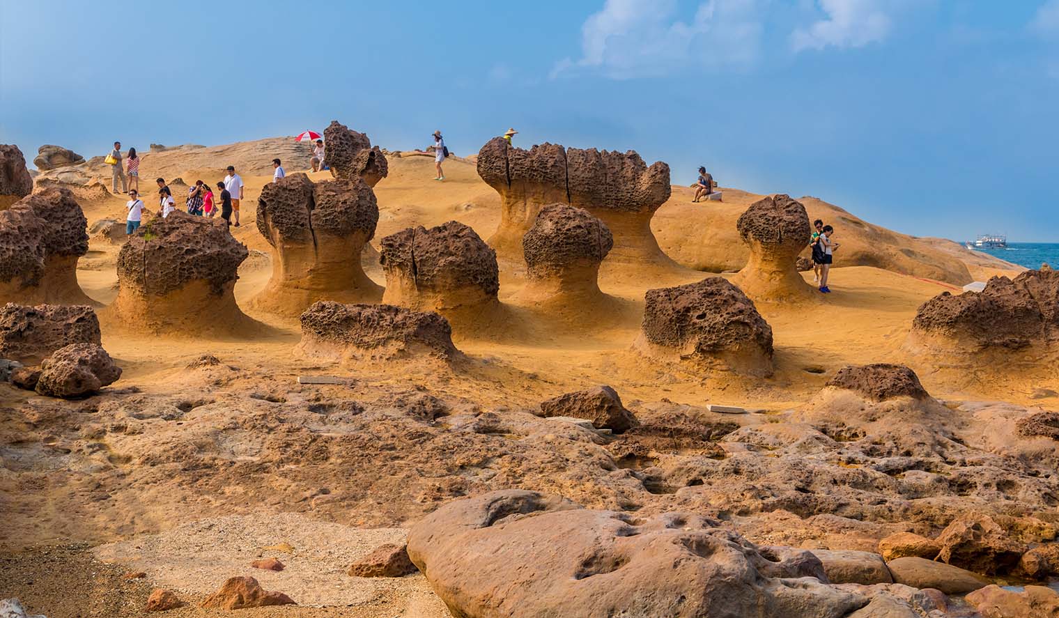 Touristen auf Taiwan Reisen besuchen die Felsformationen im Yehliu Geopark an der Küste Taiwans und erkunden die einzigartigen Naturwunder der Insel.
